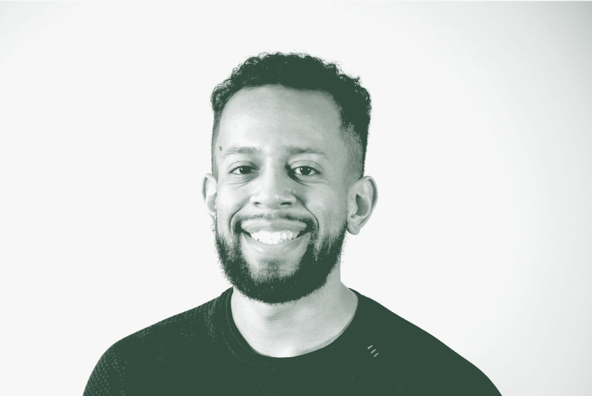 A black and white portrait of Thomas Castro, a Project Leader with GFF in the Planning Studio, in front of a white background.