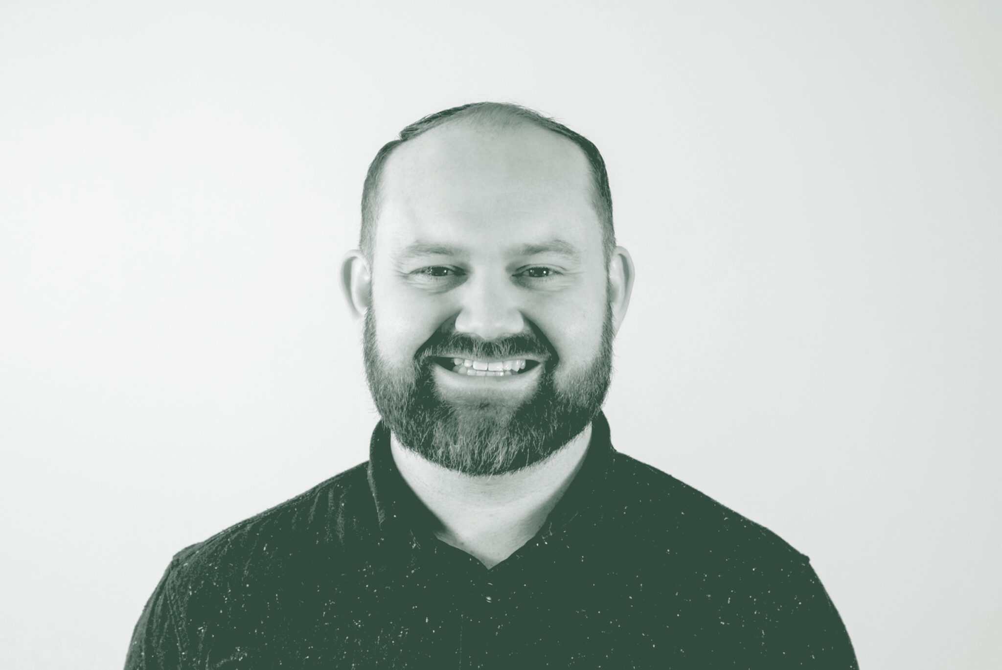 A black and white portrait of Tyler Porter, a Senior Project Coordinator with GFF in the Fort Worth Studio, in front of a white background.