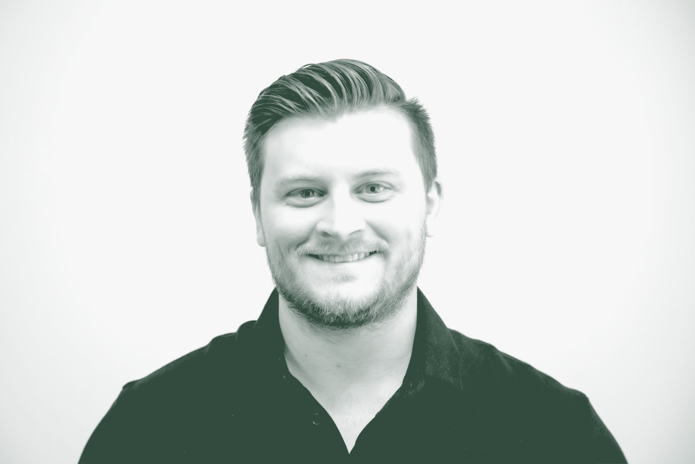 Zach McLain Portrait A black and white portrait of Zach McLain, a Design Leader with GFF in the Austin Studio, in front of a white background.