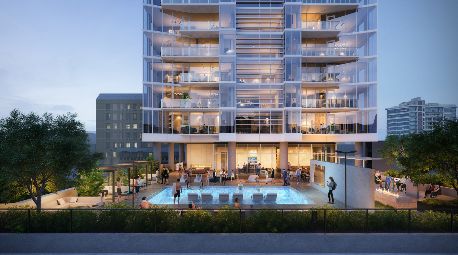 Dusk view of the residential tower’s pool deck, highlighting the pool, lounge areas, and the building’s glass façade.