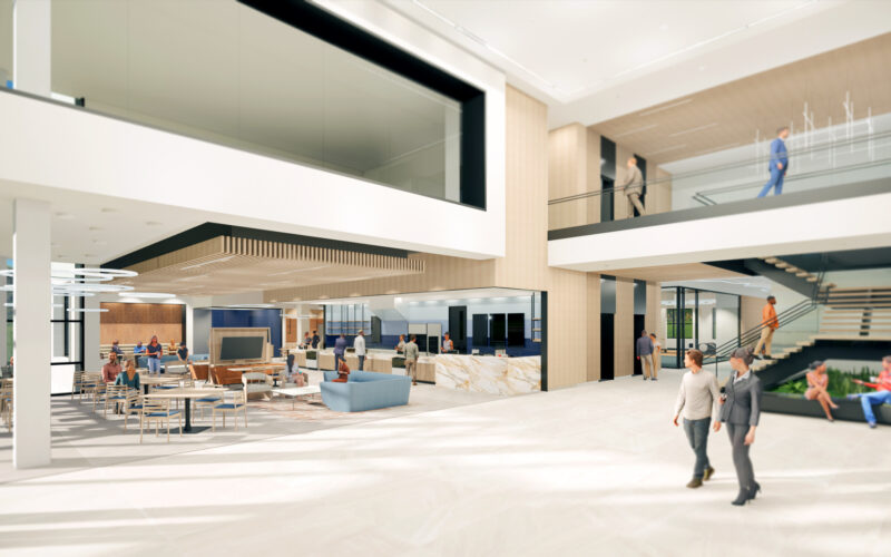 Spacious and bright corporate lobby with modern furnishings and an open stairwell leading to the second floor.