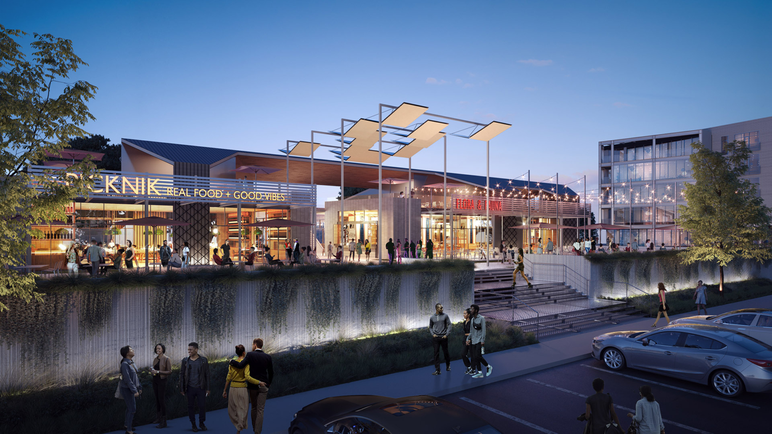 Nighttime view of the retail entrance at Barvin Braeswood, with vibrant lighting and people socializing.