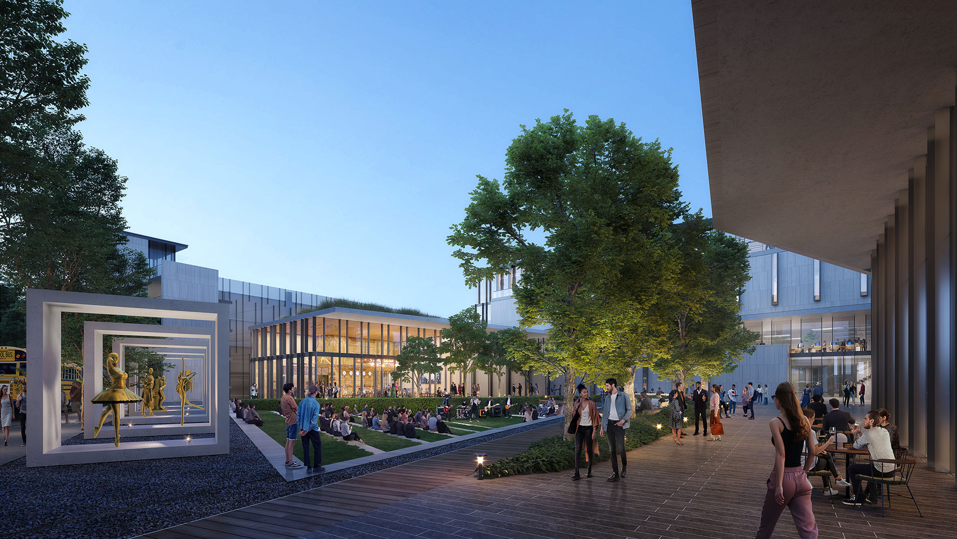 Evening view of the Center for the Arts courtyard, featuring illuminated sculptures, gathering spaces, and a backdrop of contemporary buildings.