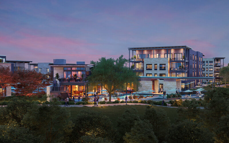 Amenity area at dusk with views of modern multifamily buildings at Pearl Bee Cave, TX, featuring warm exterior lighting, lush trees, and landscaped walkways.
