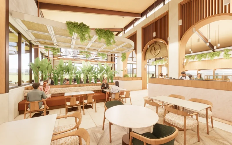 A spacious dining area at San Martin Bakery in Plano, Texas, featuring wood furnishings, lush greenery, woven pendant lighting, and large arched openings.