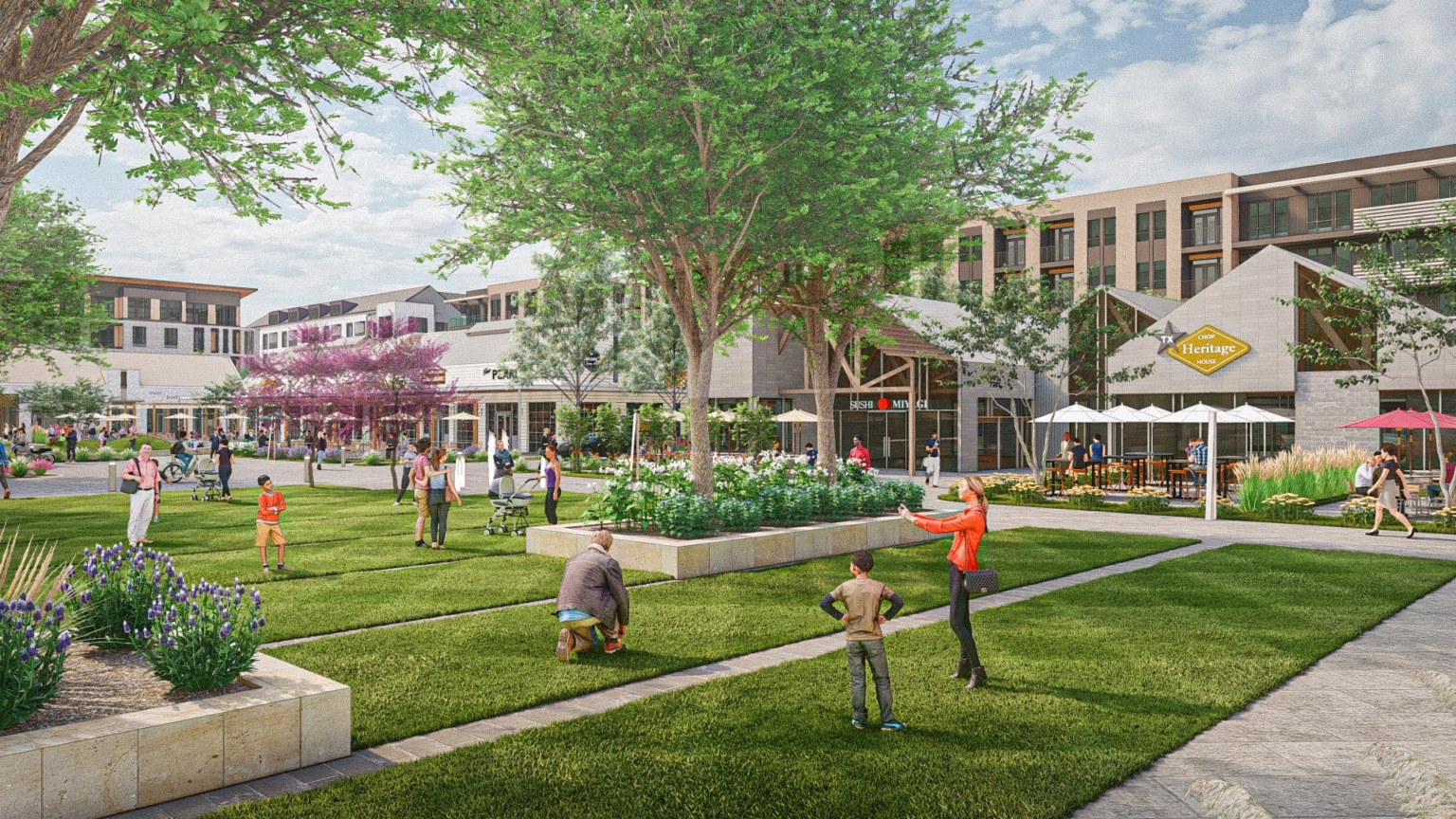 Children and families enjoy the open lawn space with restaurants behind