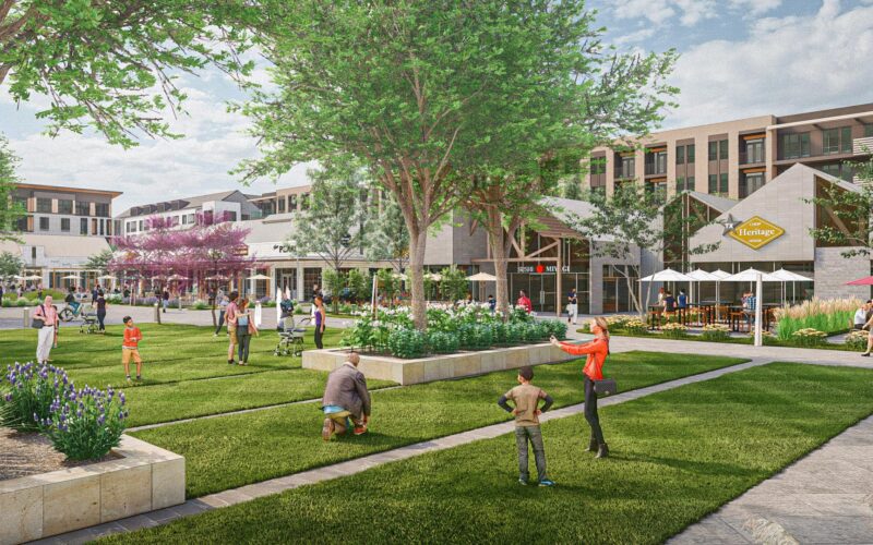 Children and families enjoy the open lawn space with restaurants behind