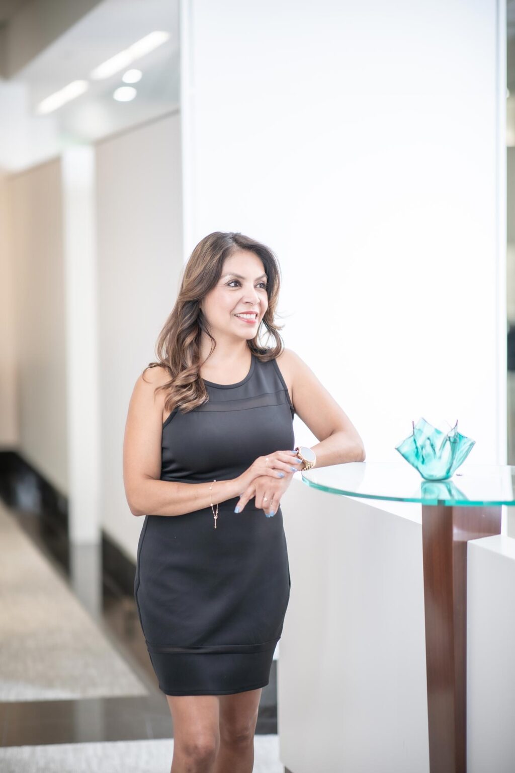 Christina Astion, Executive Assistant in GFF’s Dallas office, photographed in a bright modern workplace interior at an architecture and design firm.