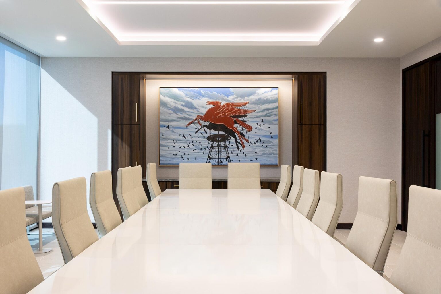 Boardroom with white table, high-back chairs, and a large painting of a red Pegasus on a cloudy sky background.