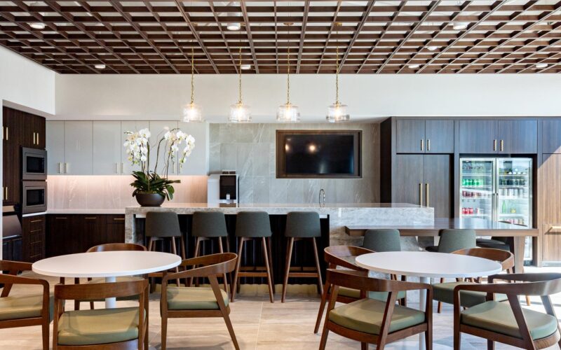 Break room with tall bar seating, built-in appliances, wood cabinetry, and orchid centerpiece.