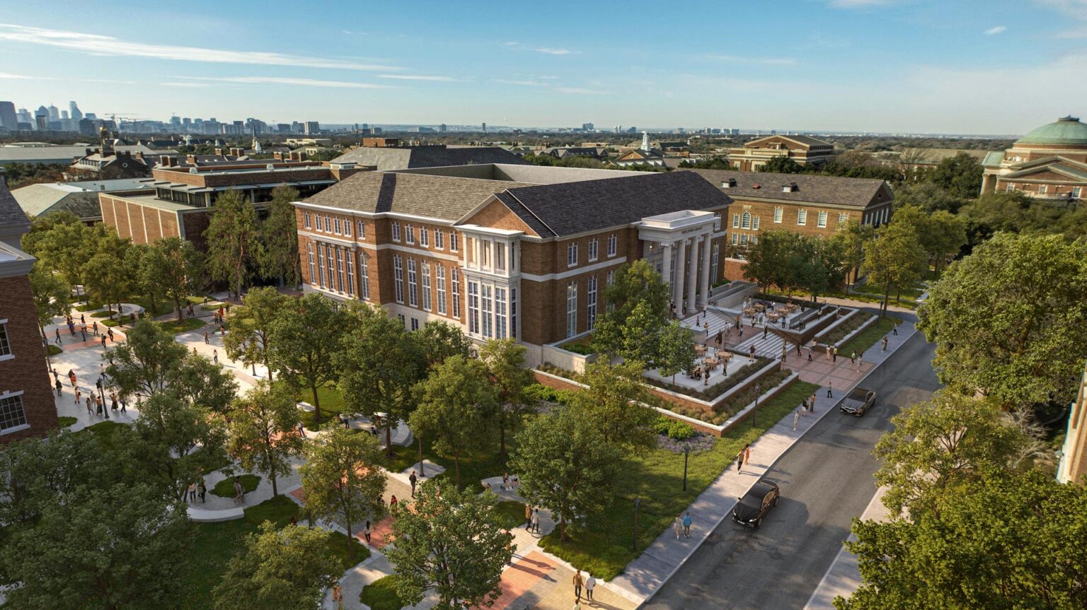 Aerial view of Rees-Jones Library showing red brick façade, grand entrance portico, landscaped campus pathways, and surrounding university buildings.