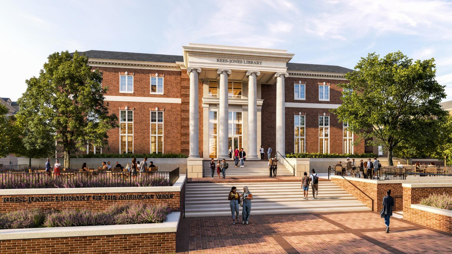 Front view of Rees-Jones Library featuring Ionic columns, brick façade, stone base, wide entry stairs, and surrounding landscaping.