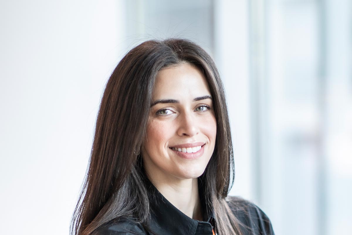 Dina Otrok, architect and interior designer at GFF, close-up professional portrait in a modern Dallas design firm setting.