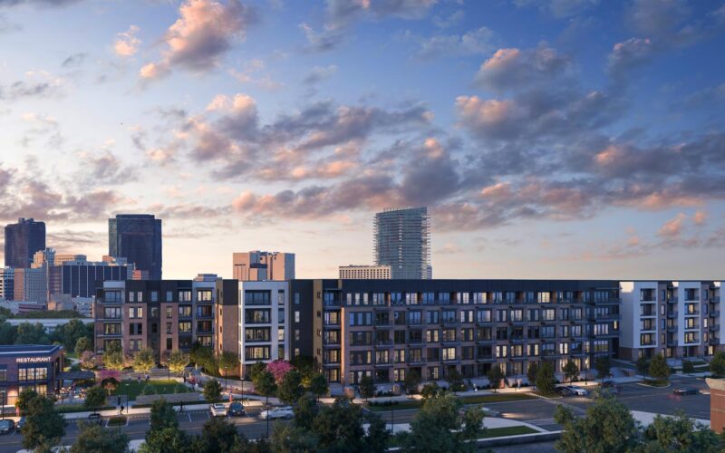 A dusk view of The Vickery in Fort Worth, a mixed-use residential development designed by GFF for Trademark Property Company, featuring a five-story apartment building, townhomes, and a standalone restaurant with downtown Fort Worth visible in the background.