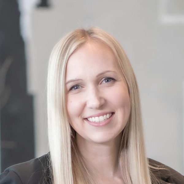 Alix Rios, Associate Principal and Studio Director at GFF, close-up headshot with straight blonde hair and a black blazer, photographed in a modern office environment.