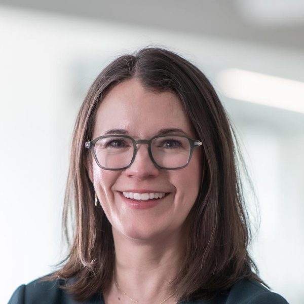 Jacquelyn Block, AIA, LEED AP, Principal and Director of Faith & Community Practice at GFF, close-up portrait with glasses in soft-focus office background.