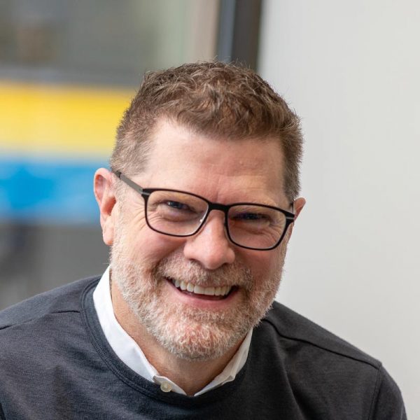 Jim West, AIA, LEED AP, NCARB, Principal and Managing Director of GFF Austin, close-up headshot in a dark sweater with blurred office background.